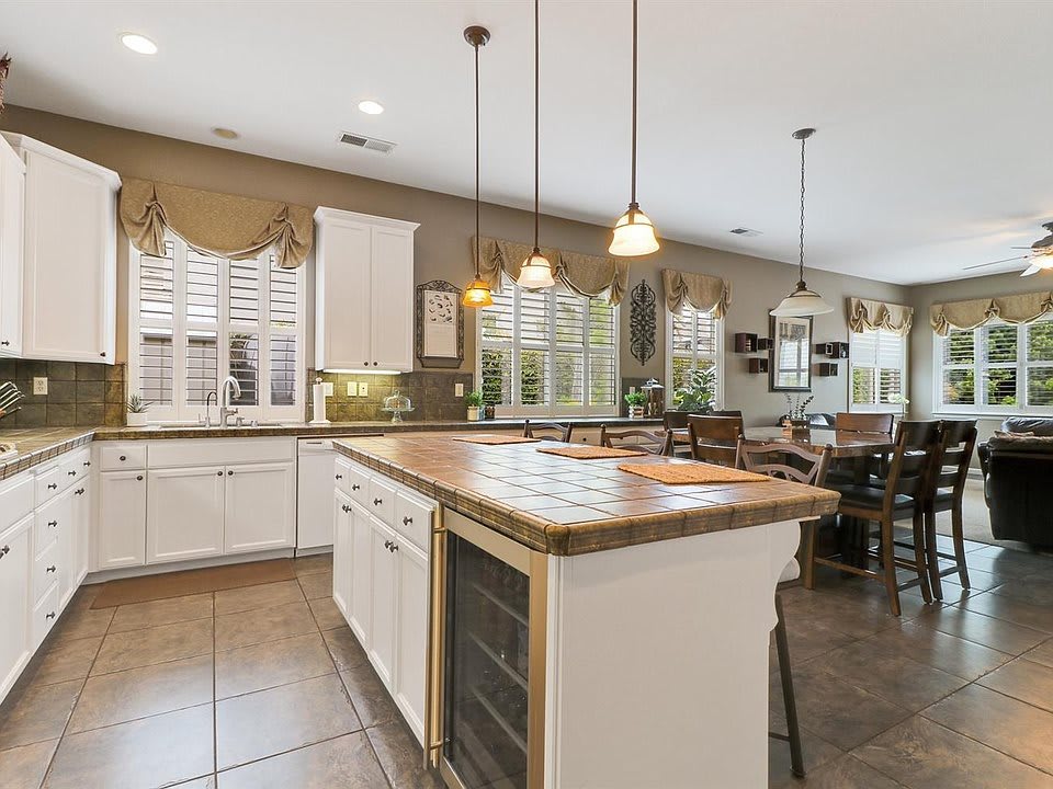 A spacious kitchen featuring a large island with pendant lighting and an open dining area.