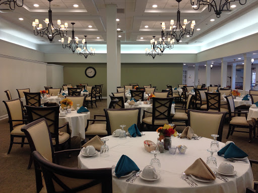 A beautifully arranged dining room featuring elegant tables and chandeliers, ready for an event.