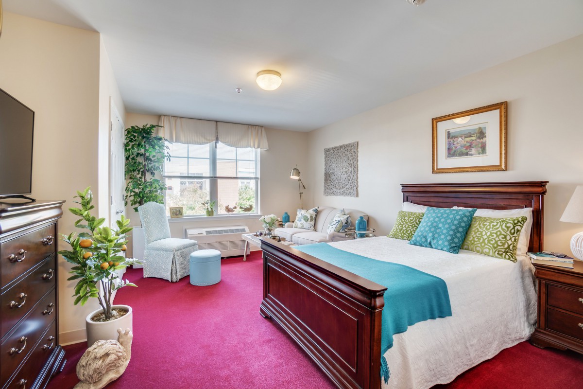 A cozy bedroom with colorful decor and ample natural light.