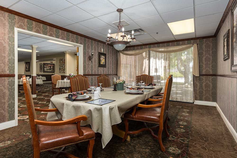 A well-appointed dining room with a wooden table and chairs, adorned by a chandelier.