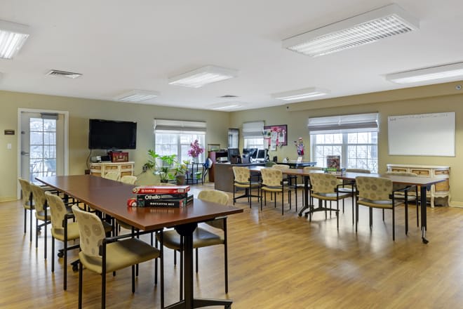 A spacious classroom with tables and chairs arranged for group activities.