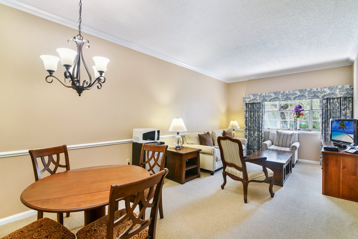 A cozy living and dining area with classic furnishings and warm lighting.