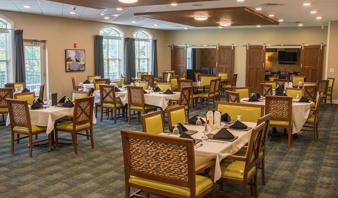 An elegantly set dining area with multiple tables and chairs, ready for guests.