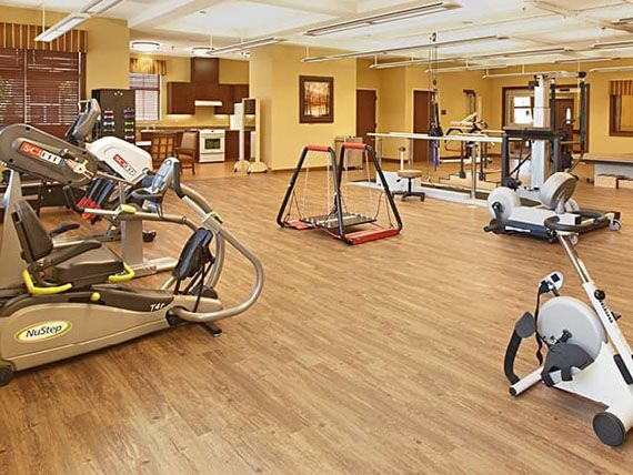 A well-equipped gym with various exercise machines and a spacious interior.