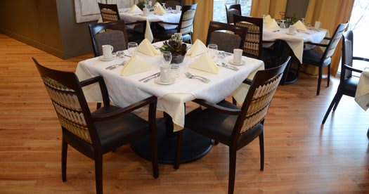 An elegantly set dining table with neatly arranged place settings in a restaurant.