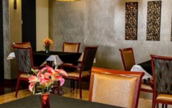 A cozy restaurant dining area with elegant decor and flower arrangements on tables.