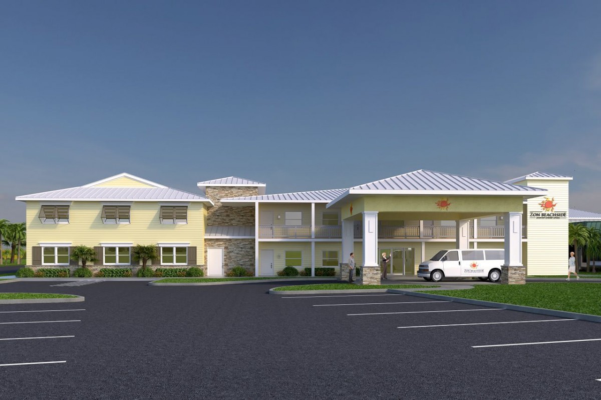 A hotel building with a parking lot and a vehicle parked outside.