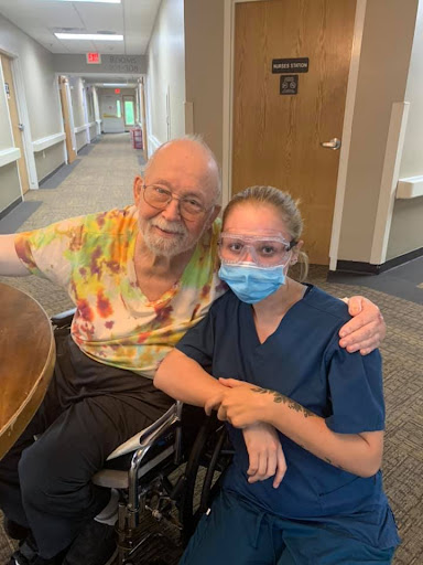 A heartwarming moment between a caregiver and an elderly resident, sharing smiles in a healthcare setting.