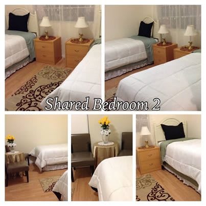 A cozy shared bedroom with twin beds, nightstands, and simple decor.