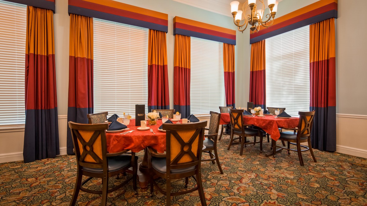 An elegantly decorated dining area with colorful curtains and neatly arranged tables.
