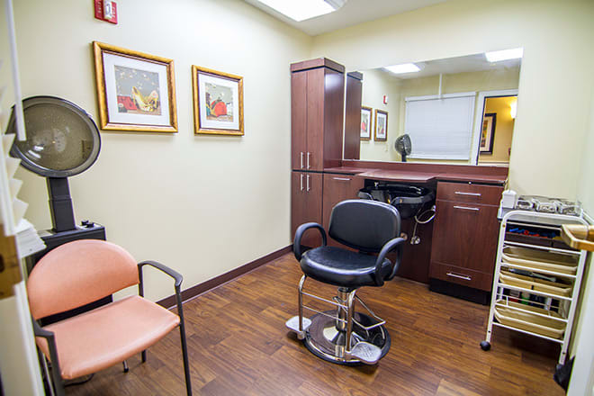 A modern hair salon interior with a barber chair and vibrant artwork on the walls.