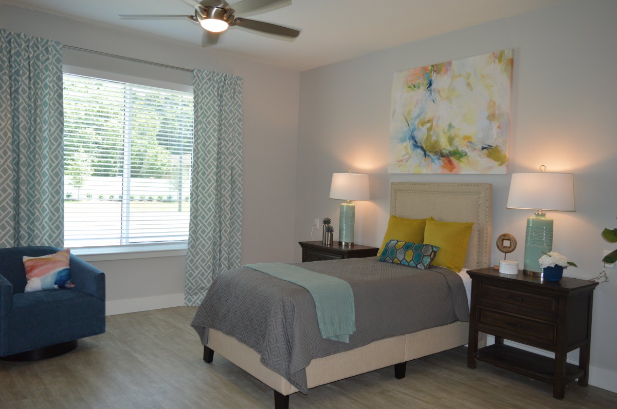 A modern bedroom with a bed, nightstand, and abstract artwork on the wall.
