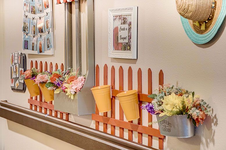 A creatively decorated wall featuring a colorful fence with buckets and flowers.