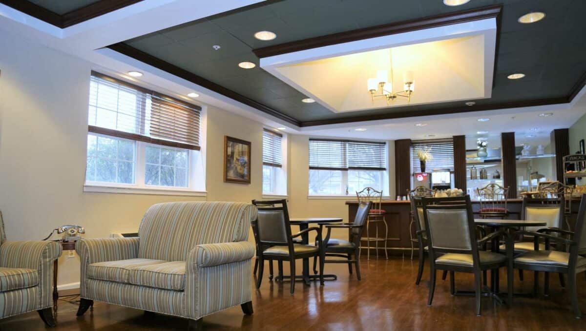 A comfortable lounge area with seating and tables, featuring soft lighting and a cozy atmosphere.