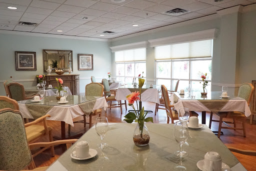 A serene dining area with elegantly set tables and floral arrangements.