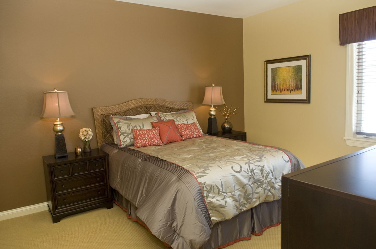 A neatly decorated bedroom with a bed, side tables, and lamps.
