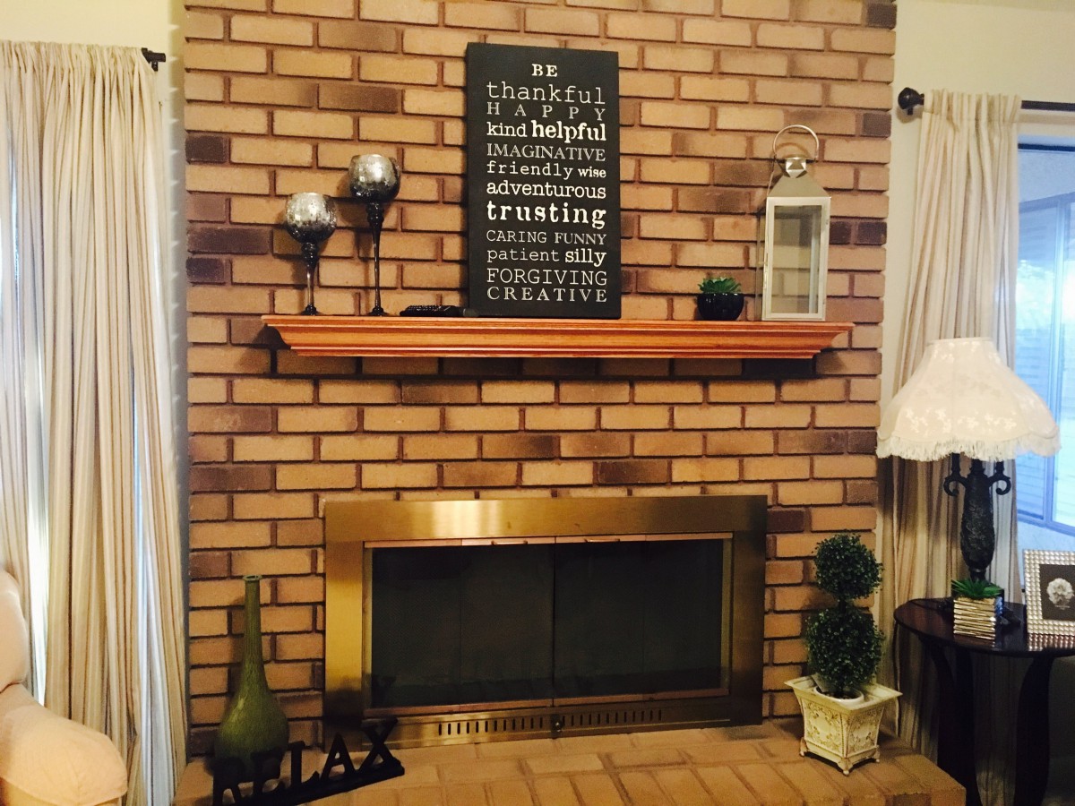 A cozy living room with a brick fireplace and decorative mantel.