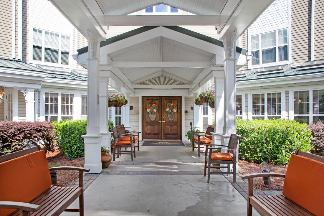 Front entrance of a building with outdoor seating and decorative landscaping.
