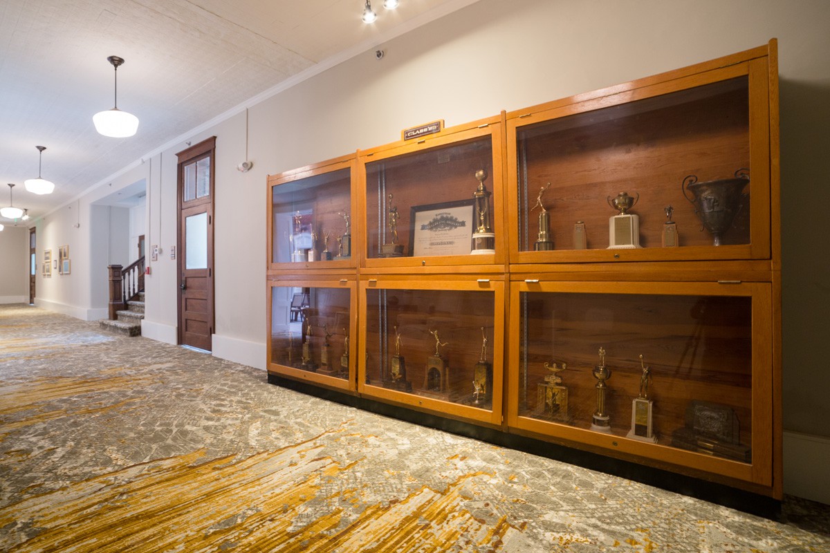 A hallway featuring wooden display cases with various artifacts.