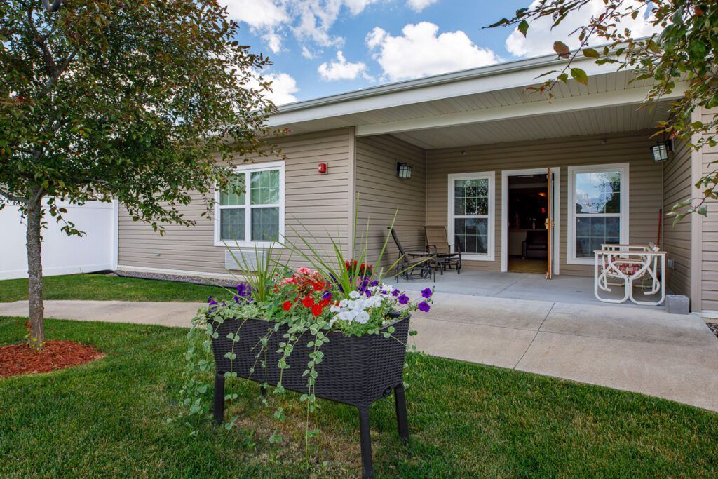 A cozy house with a garden featuring vibrant flowers and a welcoming patio area.