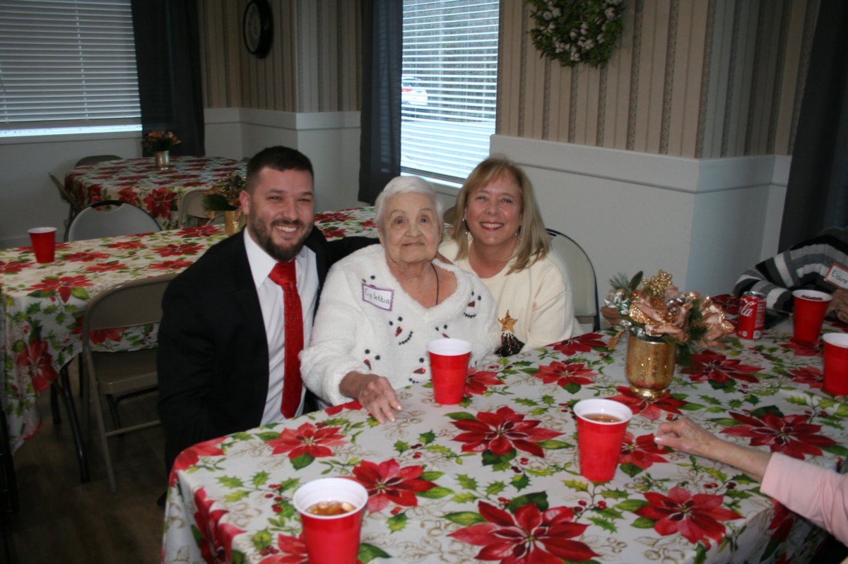 A family gathering around a festive table decorated for the holiday season.