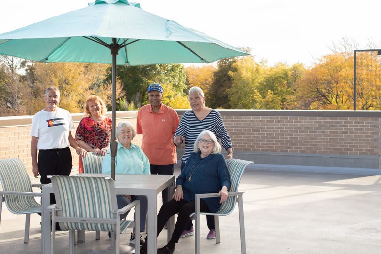 A group of seniors enjoying time together on a patio in autumn.