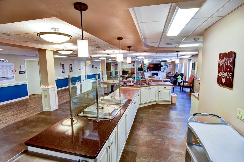A modern kitchen and dining area with sleek countertops and elegant lighting fixtures.