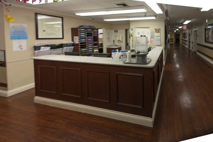 A hospital reception area with a desk and hallway.