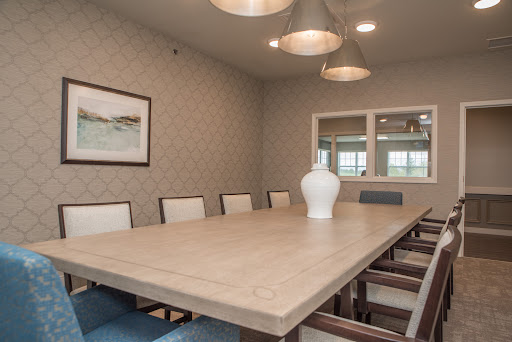 A stylish and modern dining room featuring a large wooden table, comfortable chairs, and contemporary lighting.