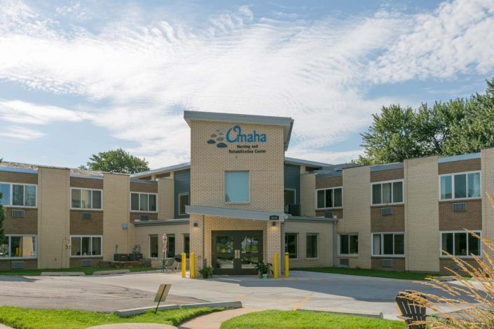 A modern clinic building with a welcoming entrance under a partly cloudy sky.