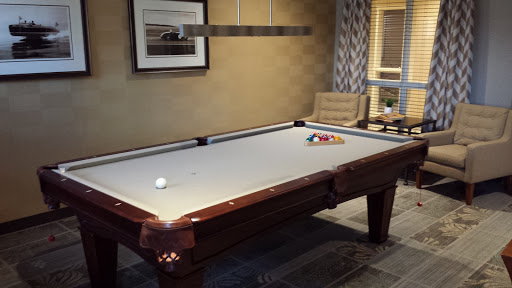 A stylish game room featuring a polished pool table ready for a match.