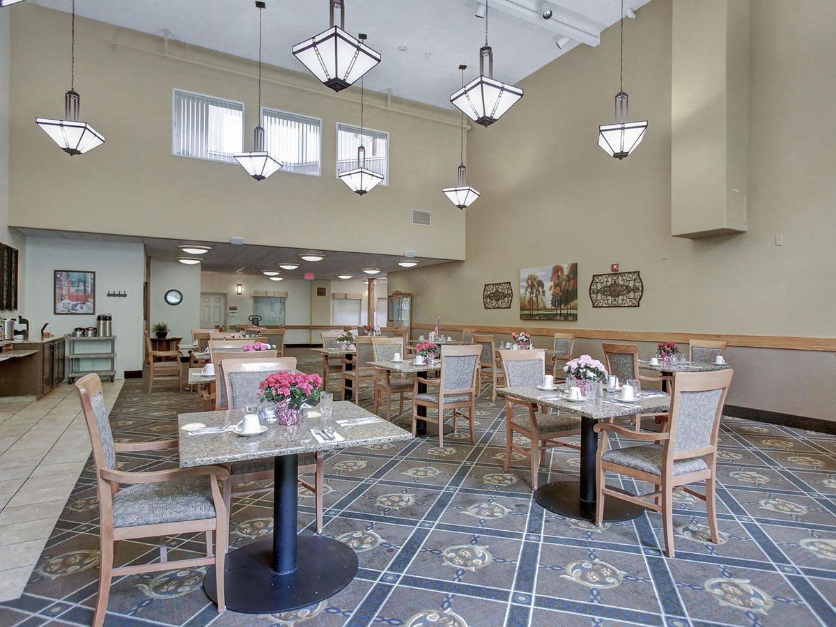 A spacious and well-lit dining area with neatly arranged tables and chairs.