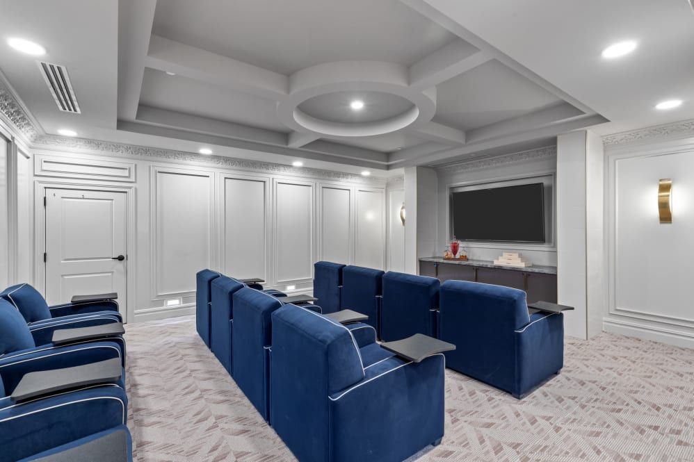 A modern home theater with blue seating and a large screen.
