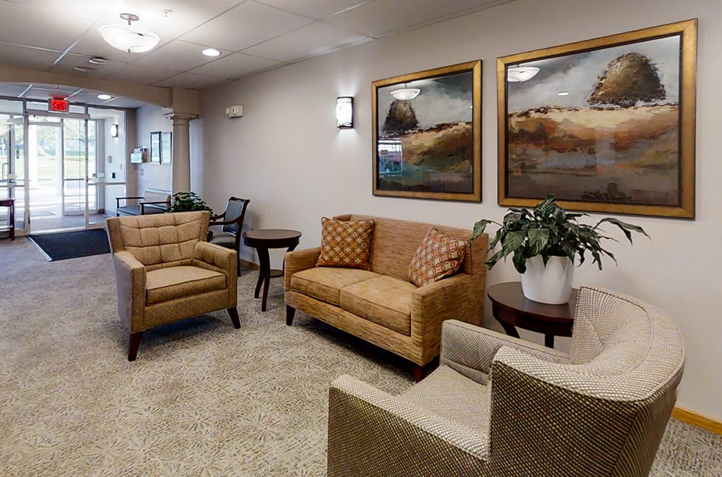 A cozy waiting room with comfortable seating and decorative artwork on the walls.