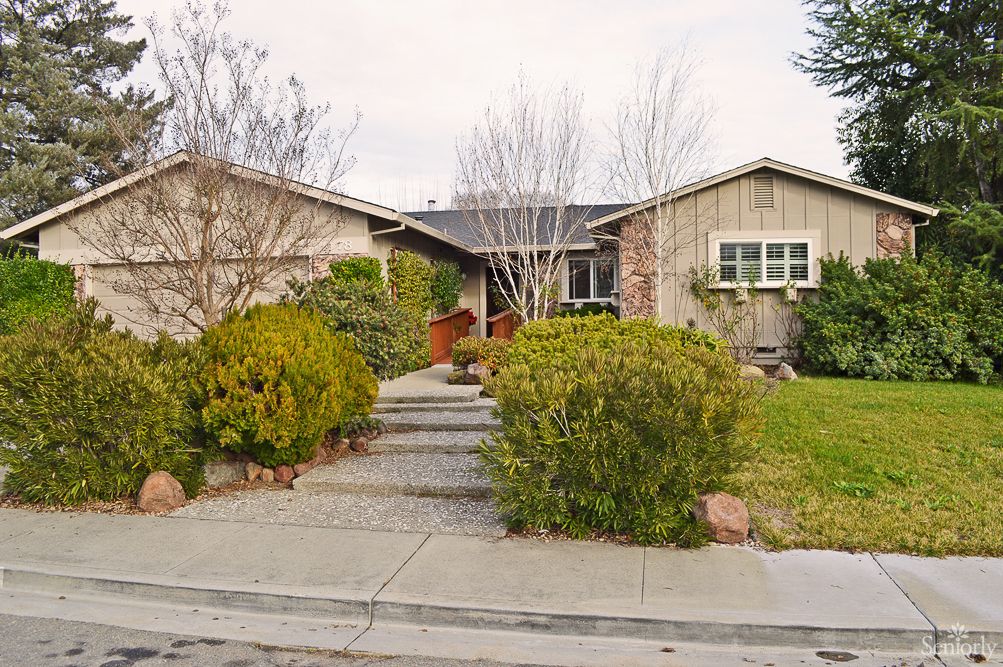 A suburban house with a landscaped front yard and pathway leading to the entrance.