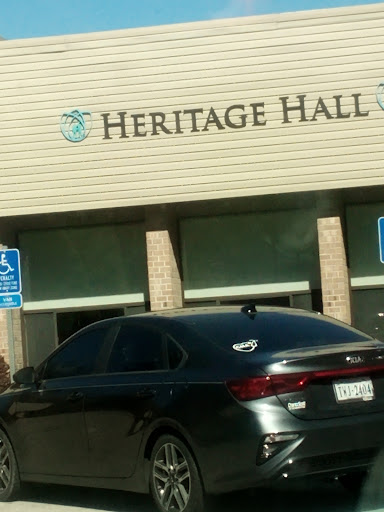 A view of Heritage Hall with a parked black car in front.