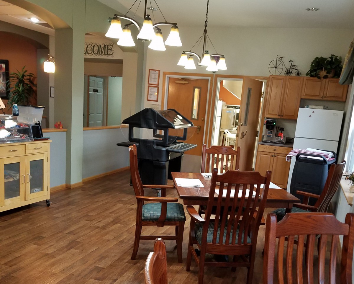 A cozy kitchen and dining area with wooden furniture and elegant lighting.