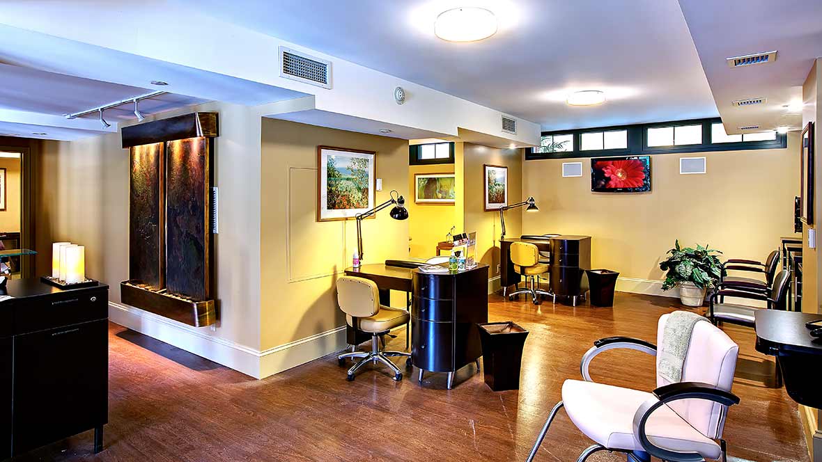 Modern salon interior with nail stations and stylish decor.