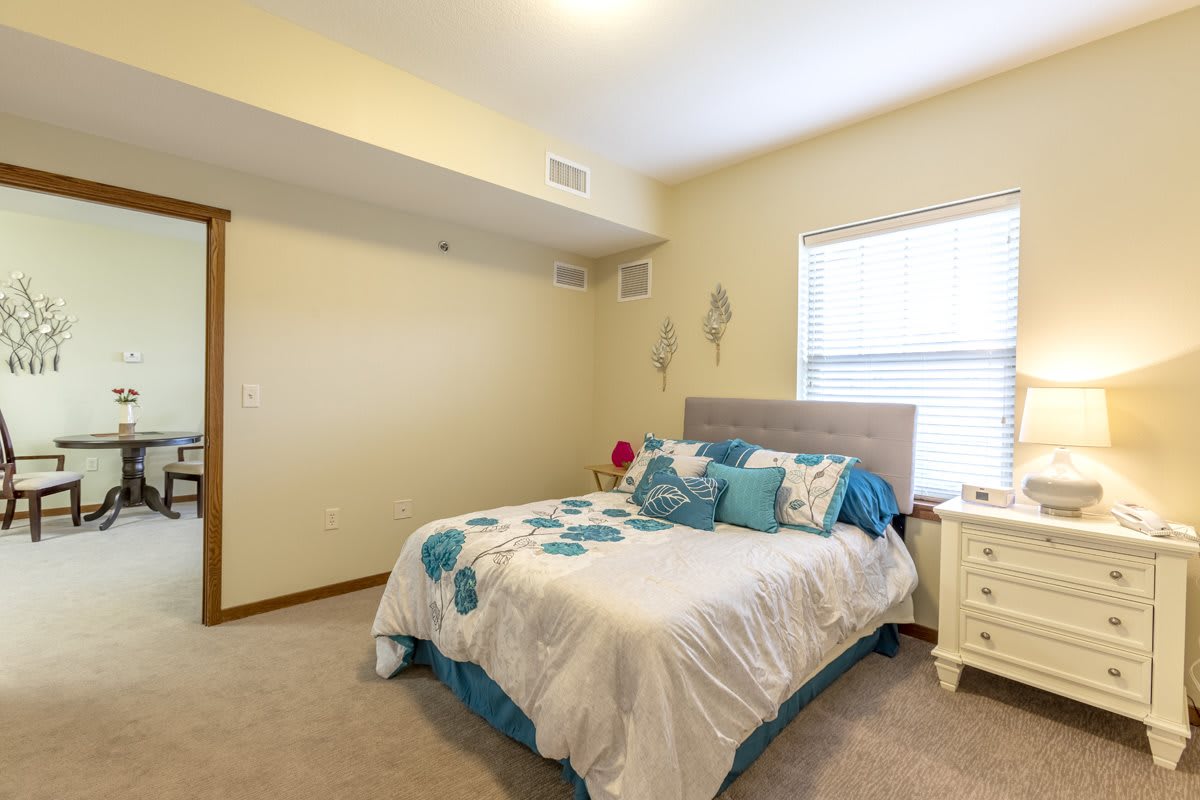 A cozy bedroom with a neatly made bed, soft lighting, and elegant decor.