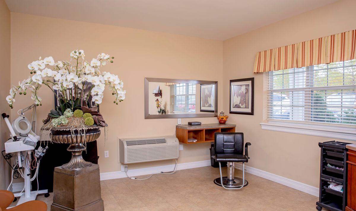 A cozy salon room with a chair, mirror, and decorative elements.