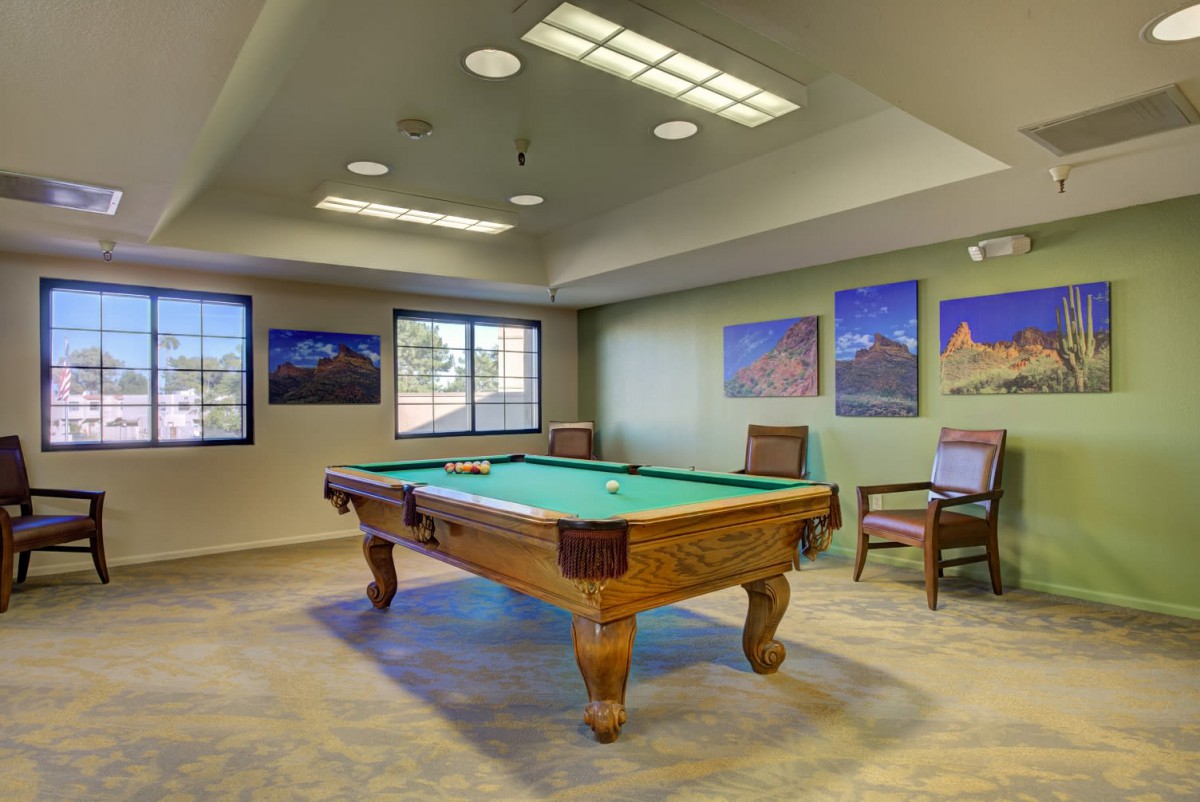 A cozy game room featuring a pool table and framed photographs on the walls.