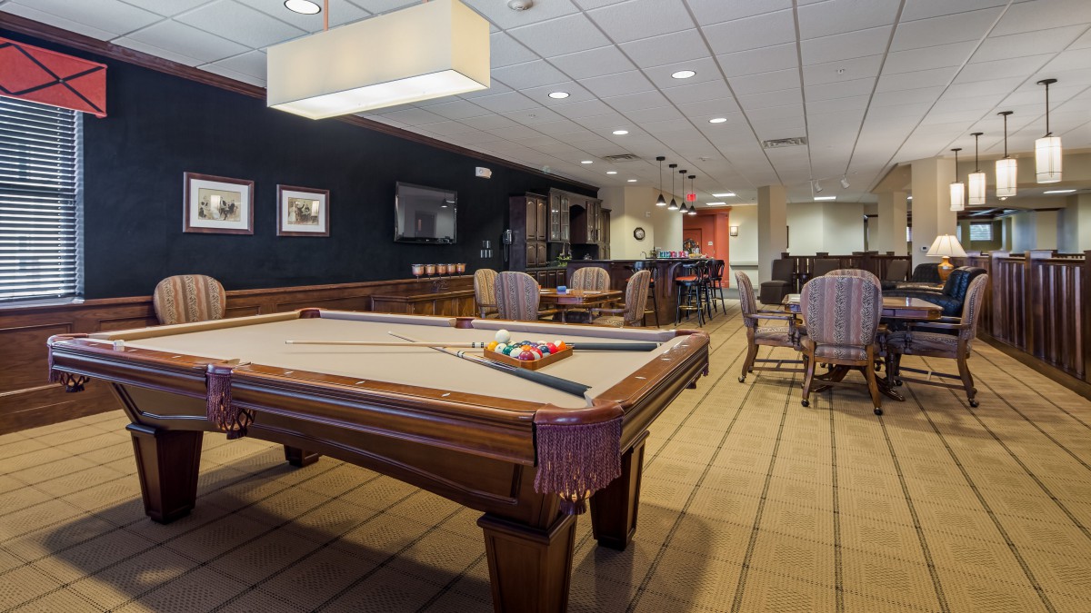 A spacious billiard room with a pool table and comfortable seating area.