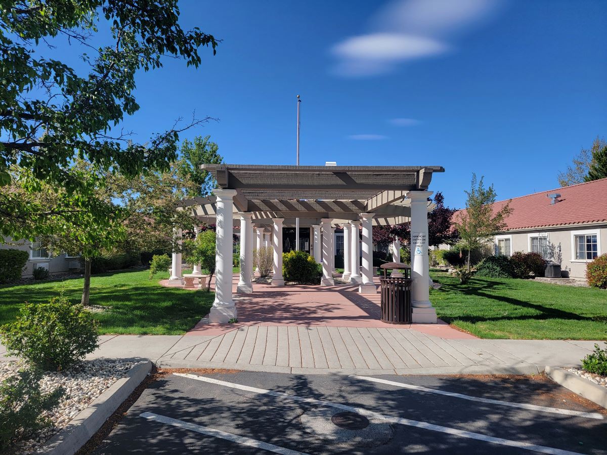 A scenic pergola in a well-maintained garden on a sunny day.