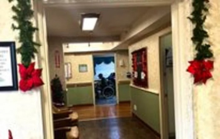 A view down a hallway with a wheelchair visible in the distance.