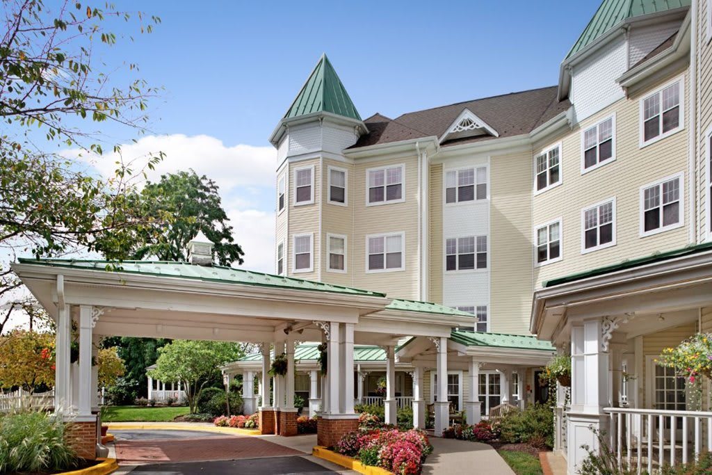 A charming residential building with a covered entrance and a well-maintained landscape.