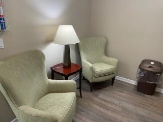 A cozy corner with two armchairs, a lamp, and a side table.