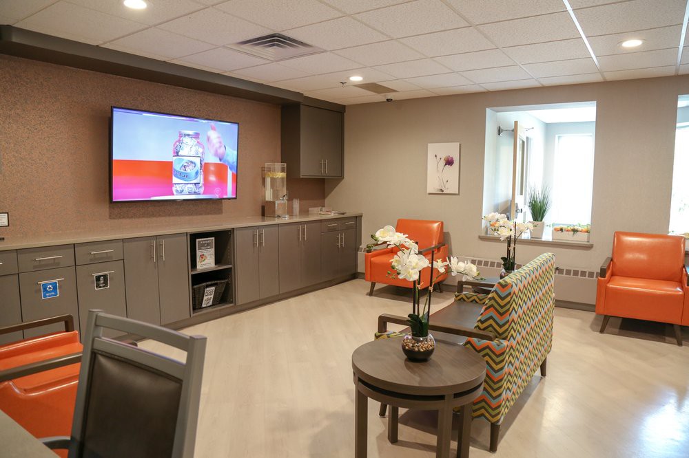 A modern living room with comfortable seating, a large wall-mounted television, and stylish decor.