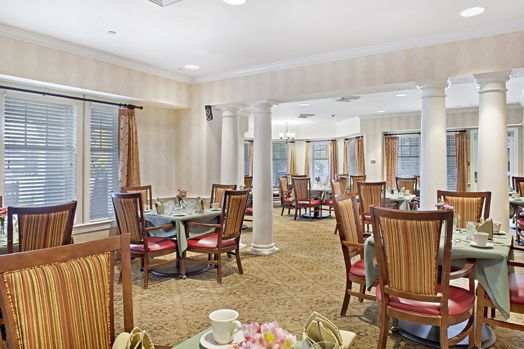 A well-lit dining area with neatly arranged tables and chairs in a cozy atmosphere.