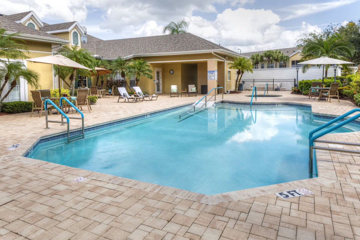 A serene outdoor pool area with loungers and sunshades, perfect for a tropical vacation.