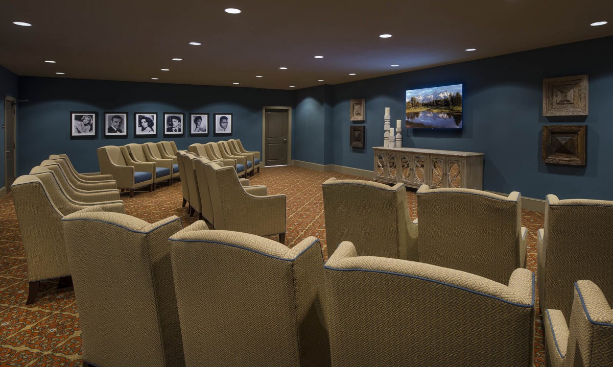 A cozy home theater room with comfortable seating and a large television screen.